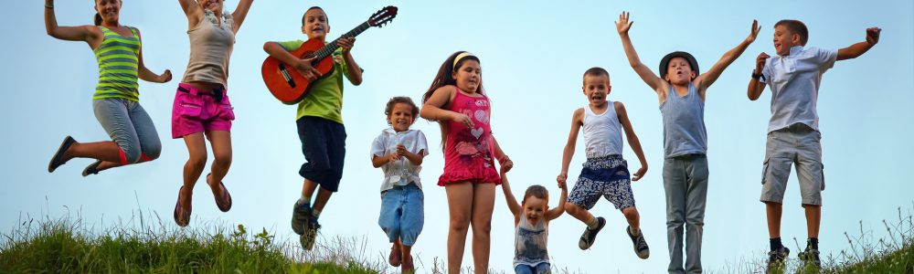 happy kids jumping on summer field